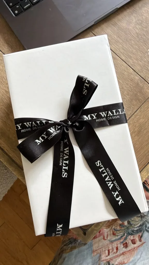 White gift box tied with a black My Walls ribbon.