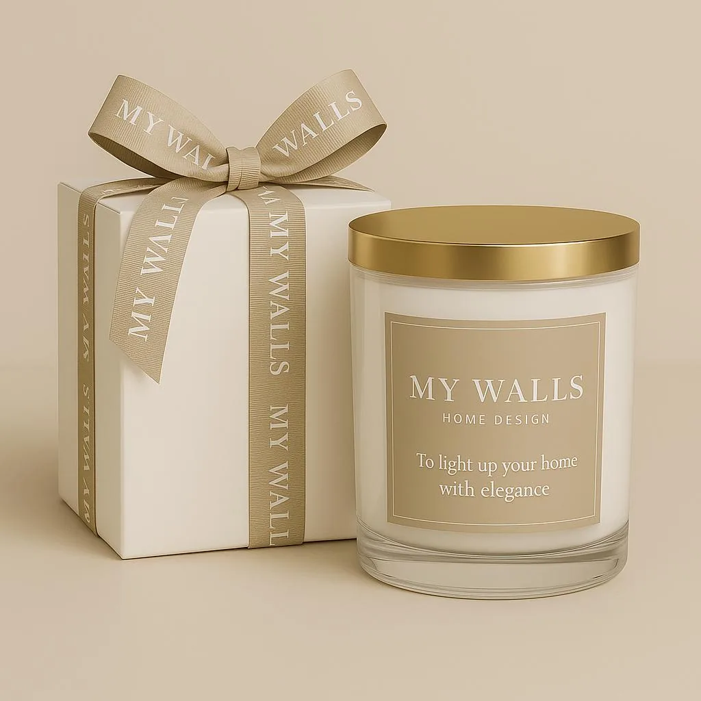 Candle with a gold lid next to a box tied with a beige My Walls ribbon.